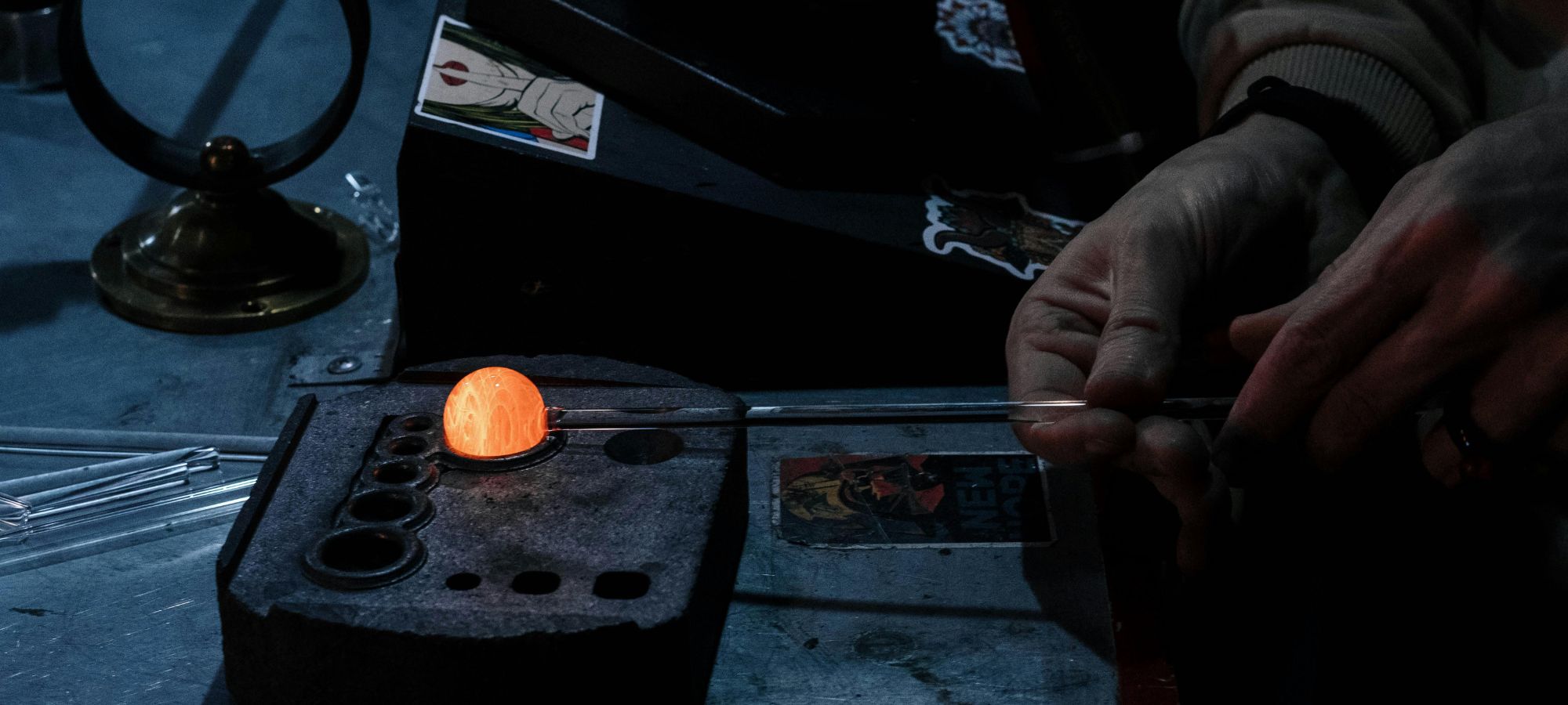 Artisanat d'art verrerie Façonnage d'une perle de verre incandescente sur un moule en graphite à l'atelier.
